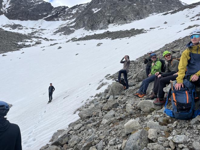 group resting rocks beside snowfield