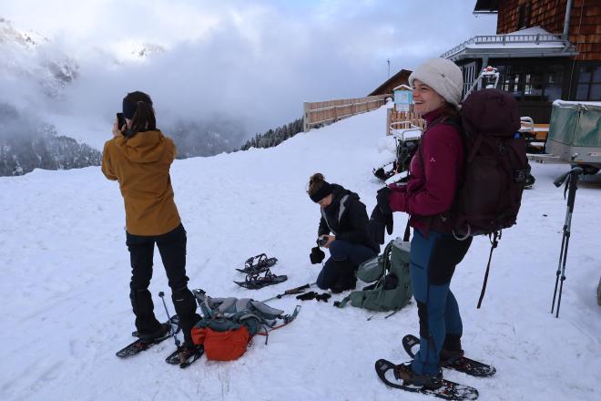 gearing up snowshoes outside mountain hut