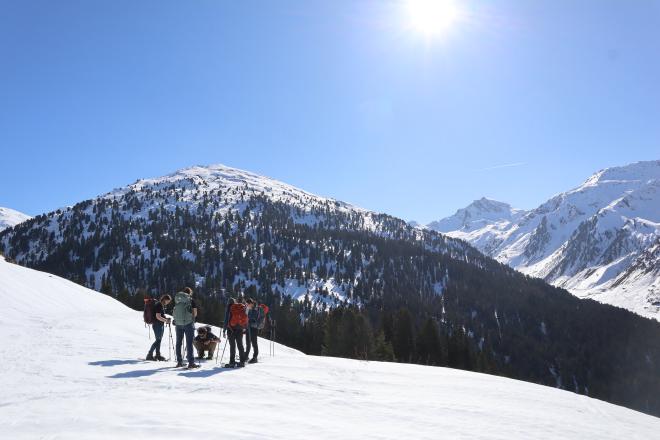 group gathering on snowy slope with alpine valley