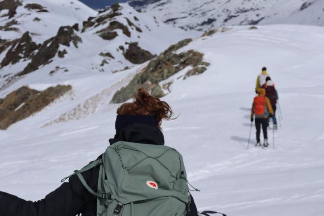 hiker with fjallraven pack on windy snowy slope