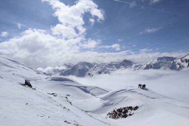 hikers at ridge edge above sea of clouds panorama