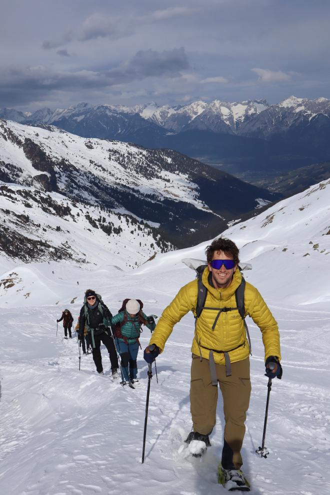 yellow jacket hiker on steep ridge with alpine panorama
